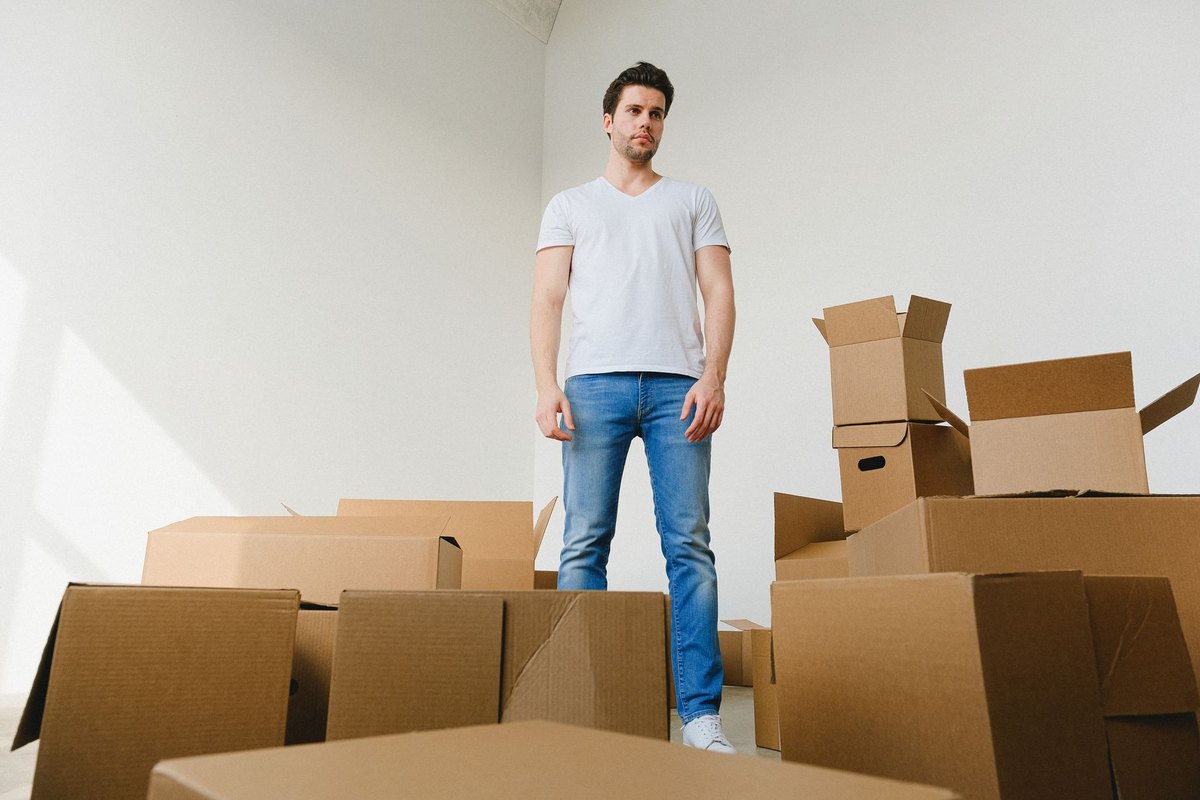 A renter standing among moving boxes