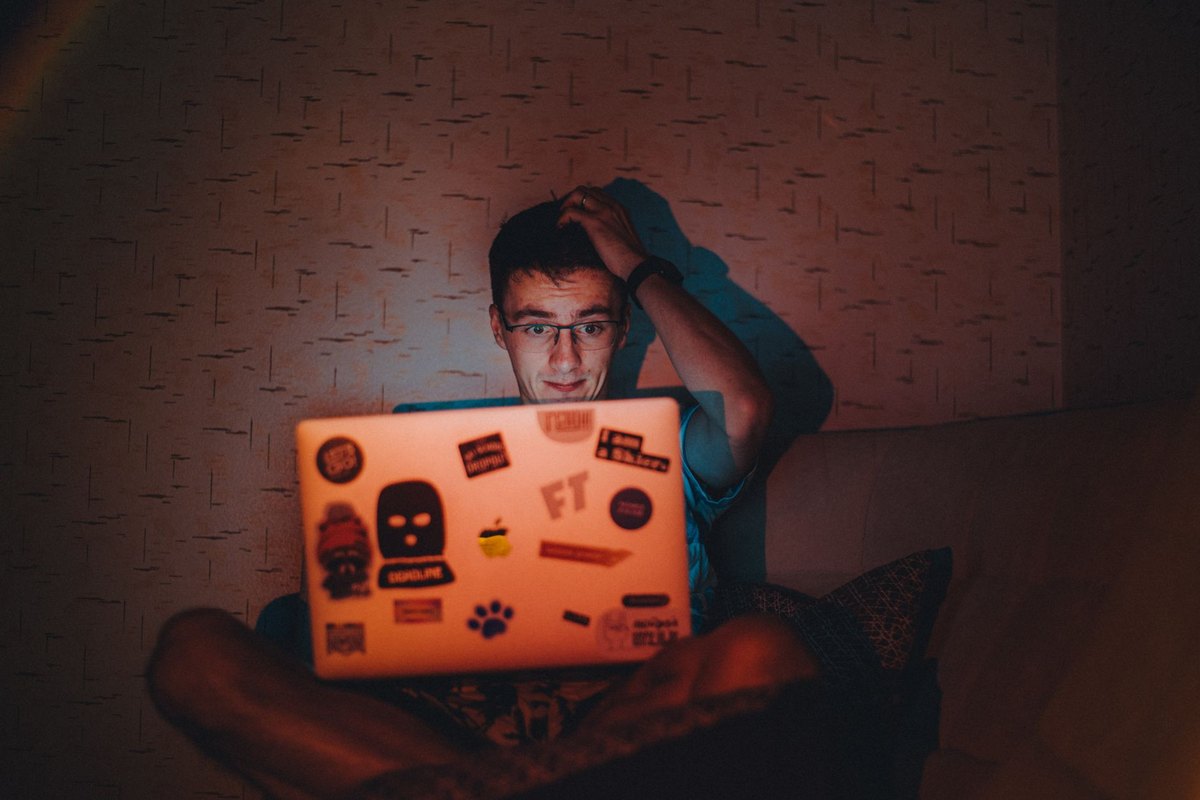 A person working on a laptop in low light